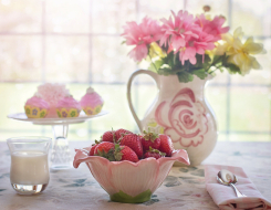 A Boul of Strawberry with a Vase of Flower